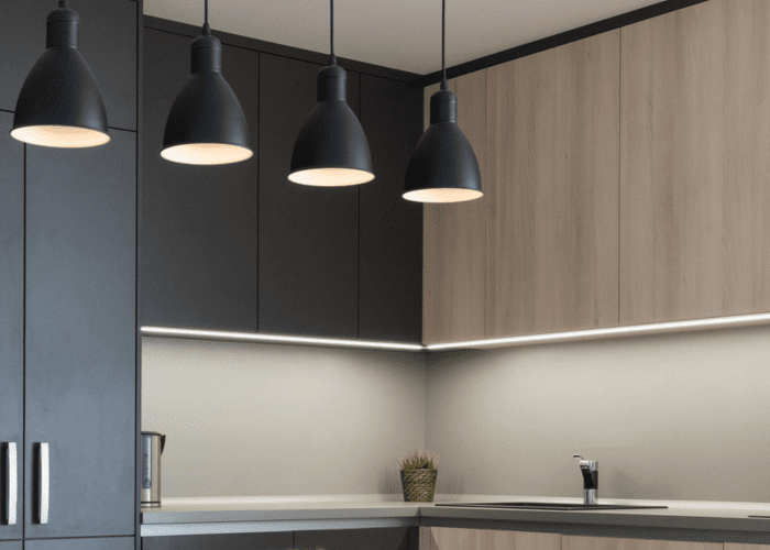 zwarte hanglampen en een led strip onder keukenkastjes
